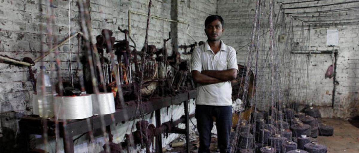 Ram Pratap, who lost his job as a powerloom operator earlier this year, poses for a picture inside a weaving factory where he used to work, in Panipat in Haryana, India, August 24, 2018. REUTERS/Adnan Abidi
