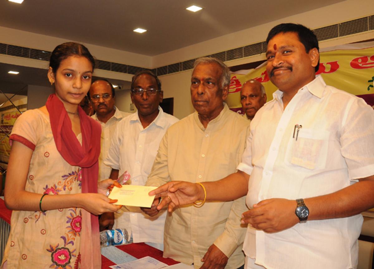 Former MLA Vellampalli Srinivasa Rao distributing scholarships to the poor students 