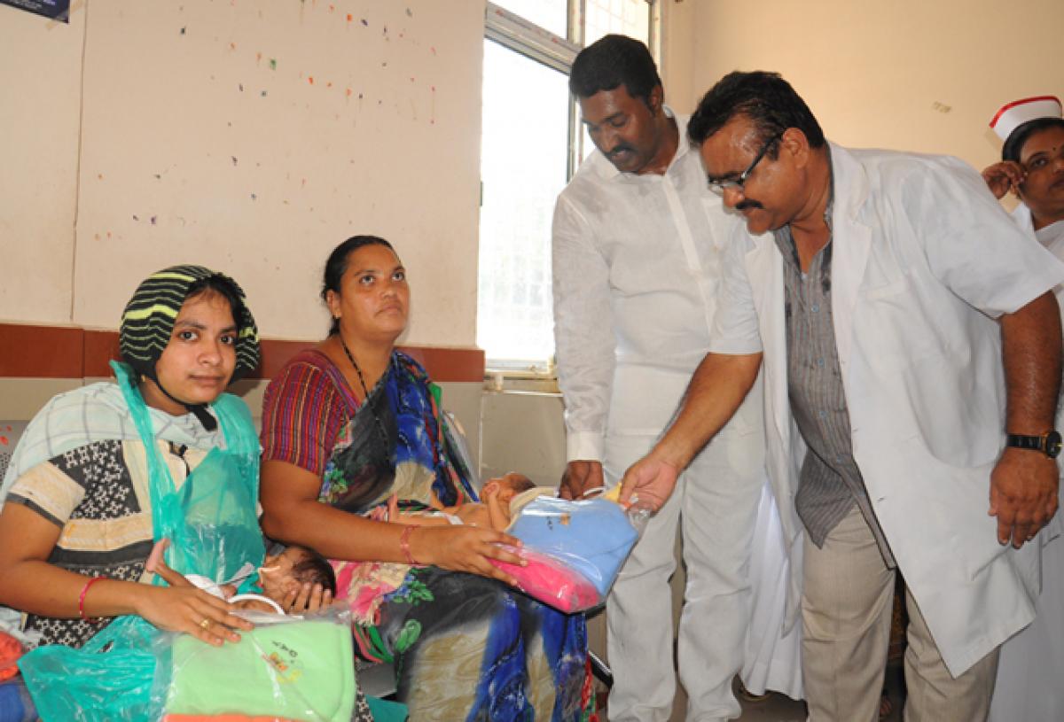 Jana Sena leader Pothina Venkata Mahesh distributing clothes to the newborns at the Old Government Hospital in Vijayawada on Wednesday to mark the birthday of Pawan Kalyan. Photo: Ch Venkata Mastan 
