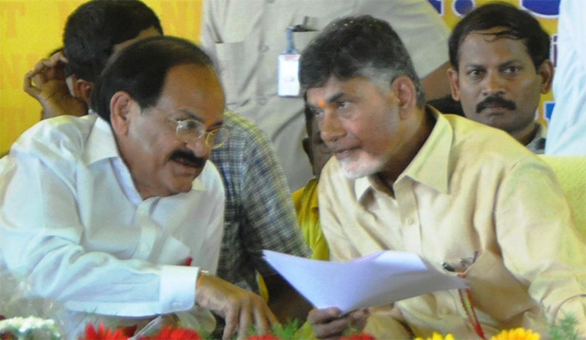 Union Minister M Venkaiah Naidu having a word with Chief Minister N Chandrababu Naidu during a public meeting organised on the occasion of laying stone for NIT at Tadepalligudem in West Godavari district on Thursday. 