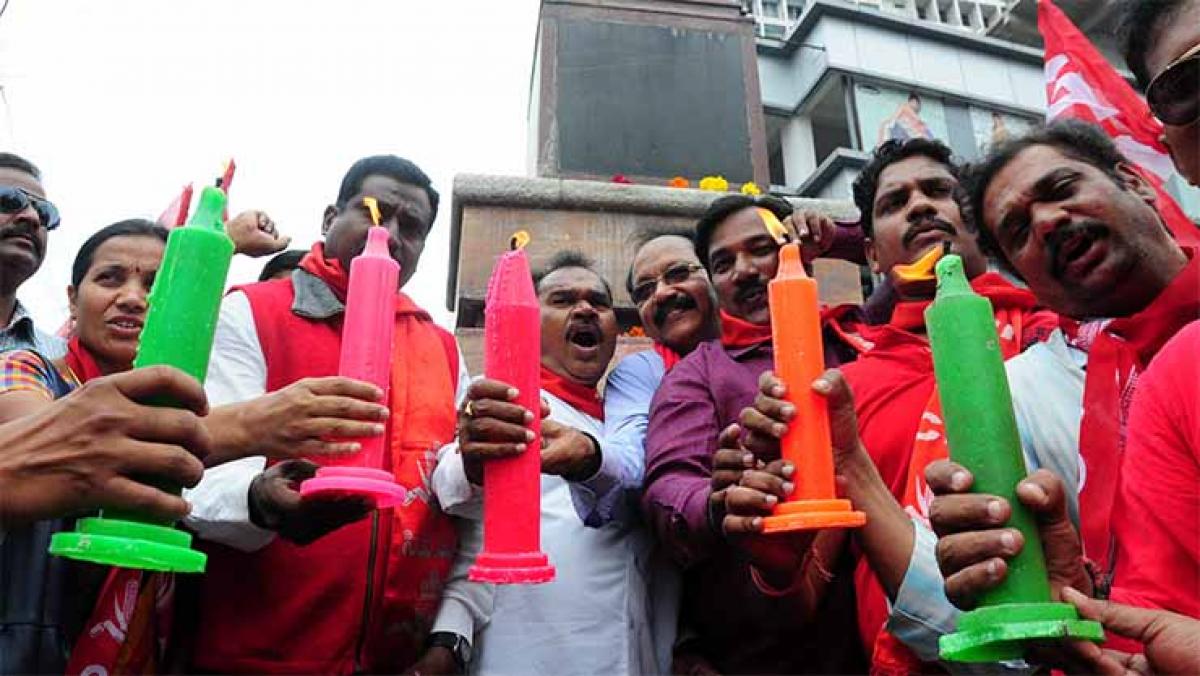 Activists of political parties holding candles in memory of Basheerbagh martyrs on Friday.   
