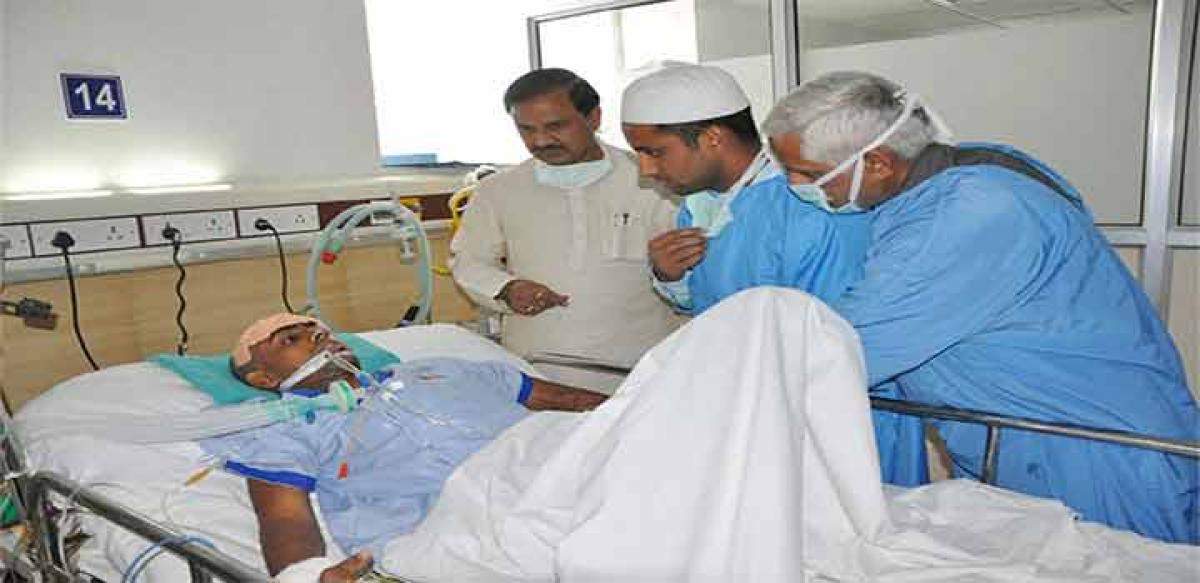 Tourism Minister Mahesh Sharma meeting Danish who was beaten up by the mob over rumor of cow slaughtering and stacking beef, at a hospital in Noida on Friday. 