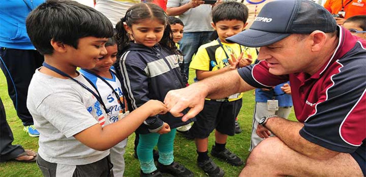 Gilchrist in an animated discussion with some starry-eyed children