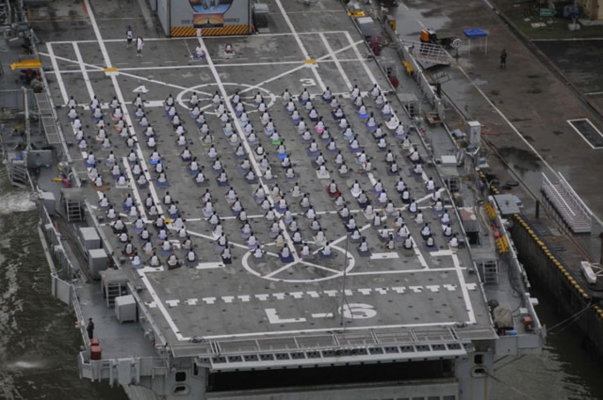 Naval personnel and their family members take part in yoga session organised aboard French Naval ship Dixmude in Visakhapatnam on Sunday