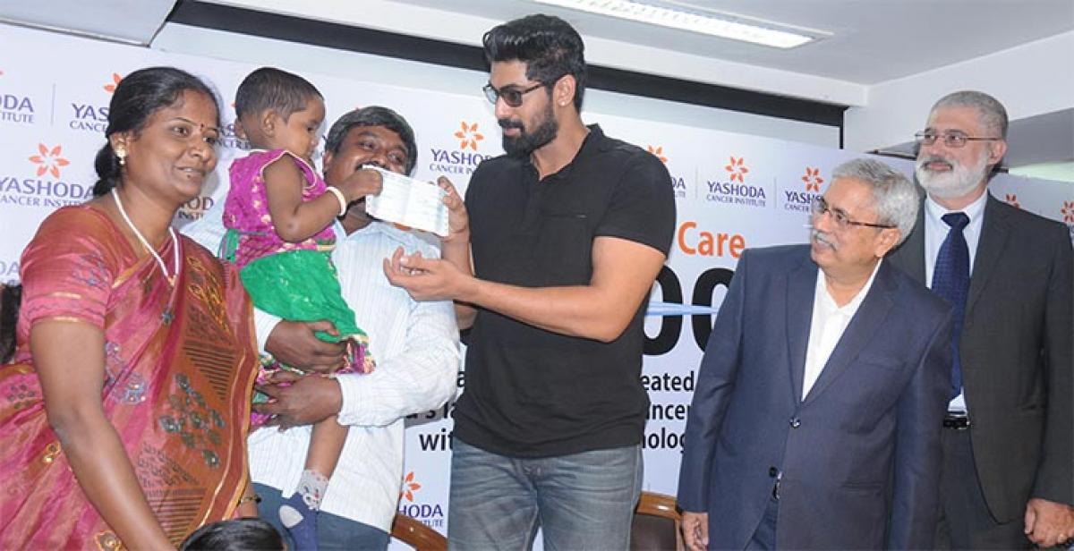  Rana Daggubati handing over a cheque for rupees two lakh  to a three-year old cancer survior
