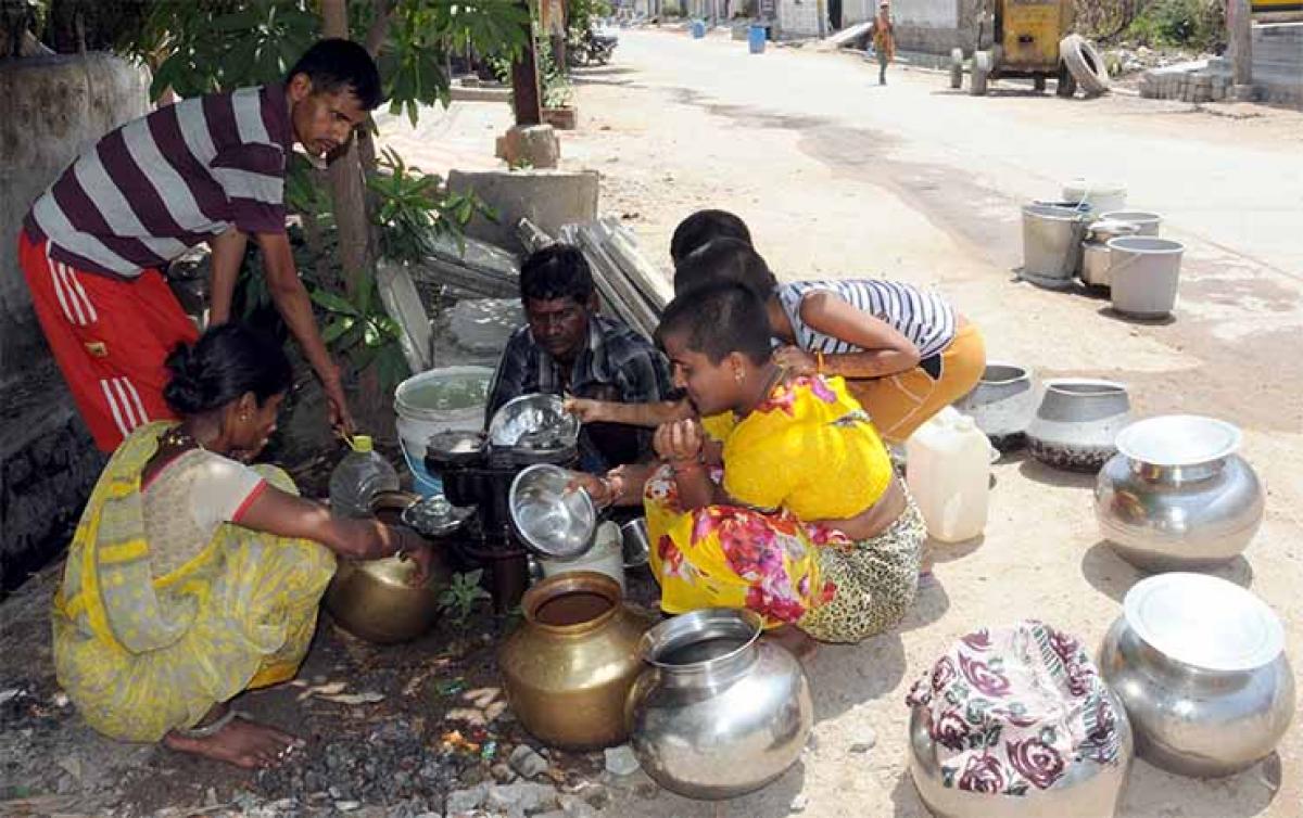 Women collecting water that is leaking from a water supply line in Warangal on Monday