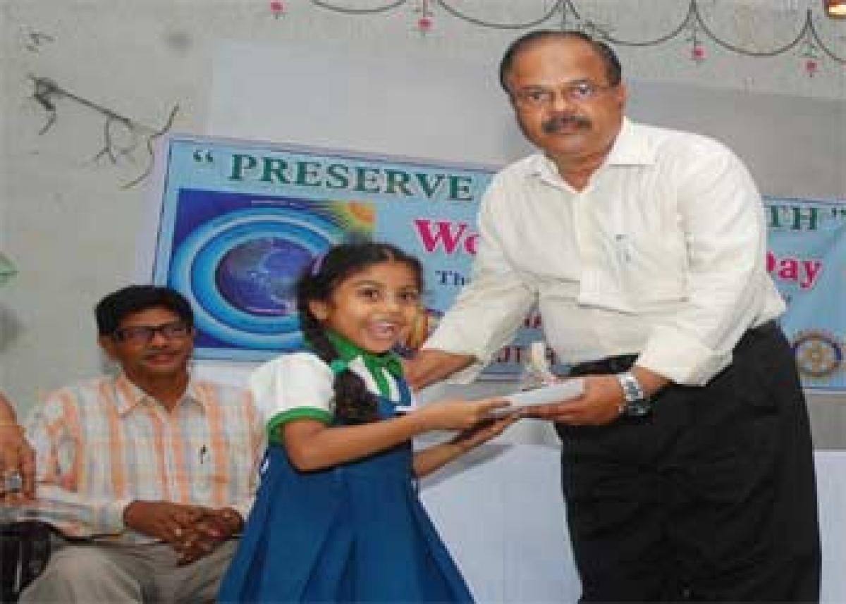 APPCB Joint Chief Environmental Engineer NV Bhaskar Rao giving away prize to a winner