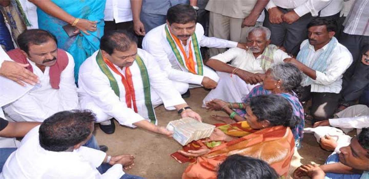 Congress leaders handing over ` 1 lakh to the widow of  Limbaiah in Nizamabad on Thursday