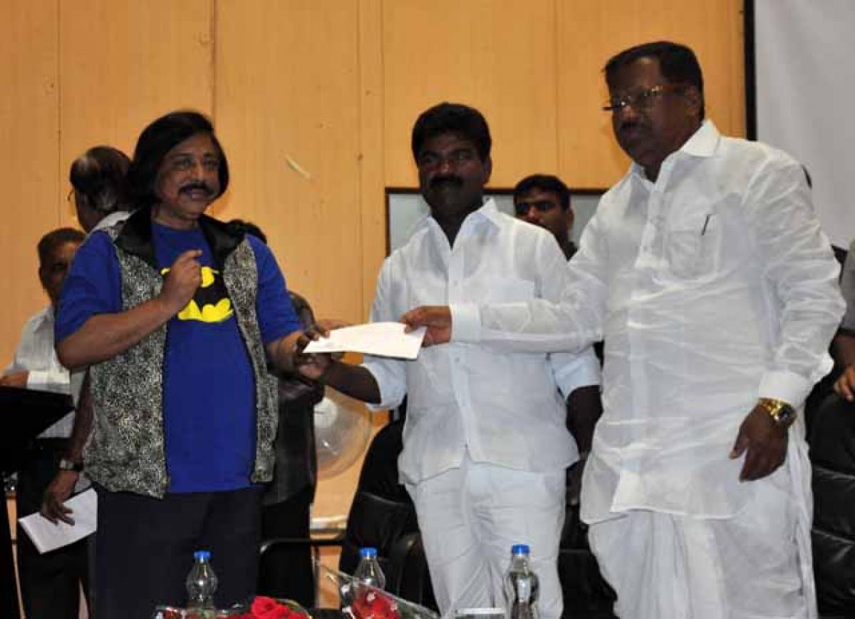 tourism Minister  Ajmeera Chandulal presenting cash award to photographer-artist Bharat Bhushan at State Arts gallery, madhapur in Hyderabad on Sunday while chairman Telangana samskrutika sarathi Rasamayi balakishan looks on. Photo: Mir Zulfequar ali