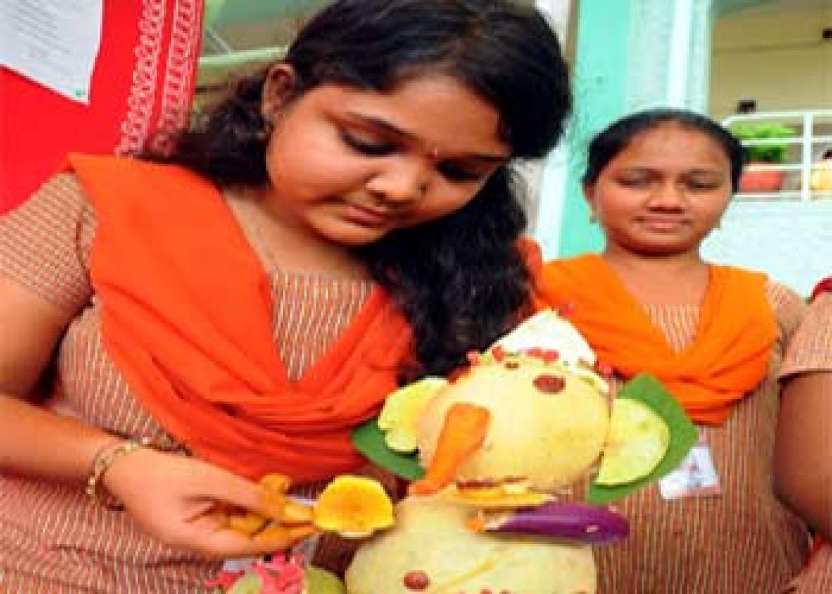 Students participating in an eco-friendly Ganesh idol making competition at Sri Durga Malleswara Siddhartha Mahila Kalasala
