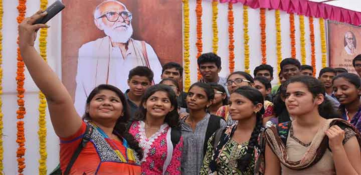 College students taking selfie with the portrait of Kaloji in Hyderabad on Wednesday
