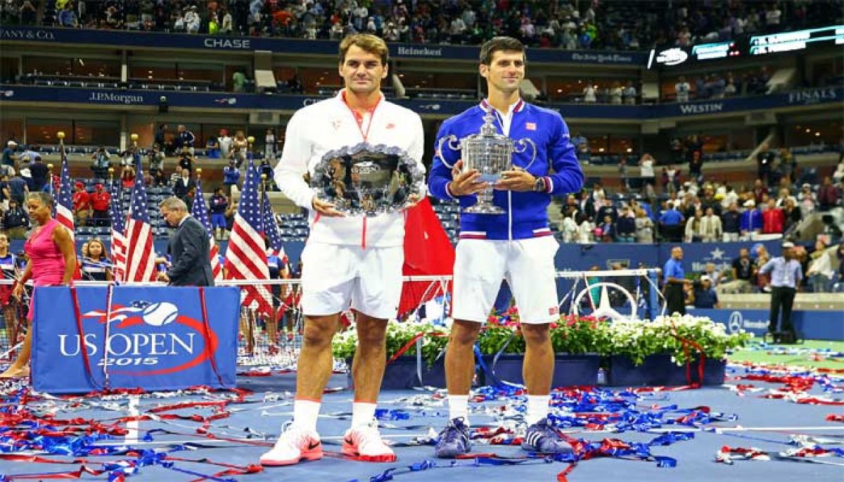 US Open winner Novak Djokovic(right) and Roger Federer with their trophies after the men singles final in New York on Sunday