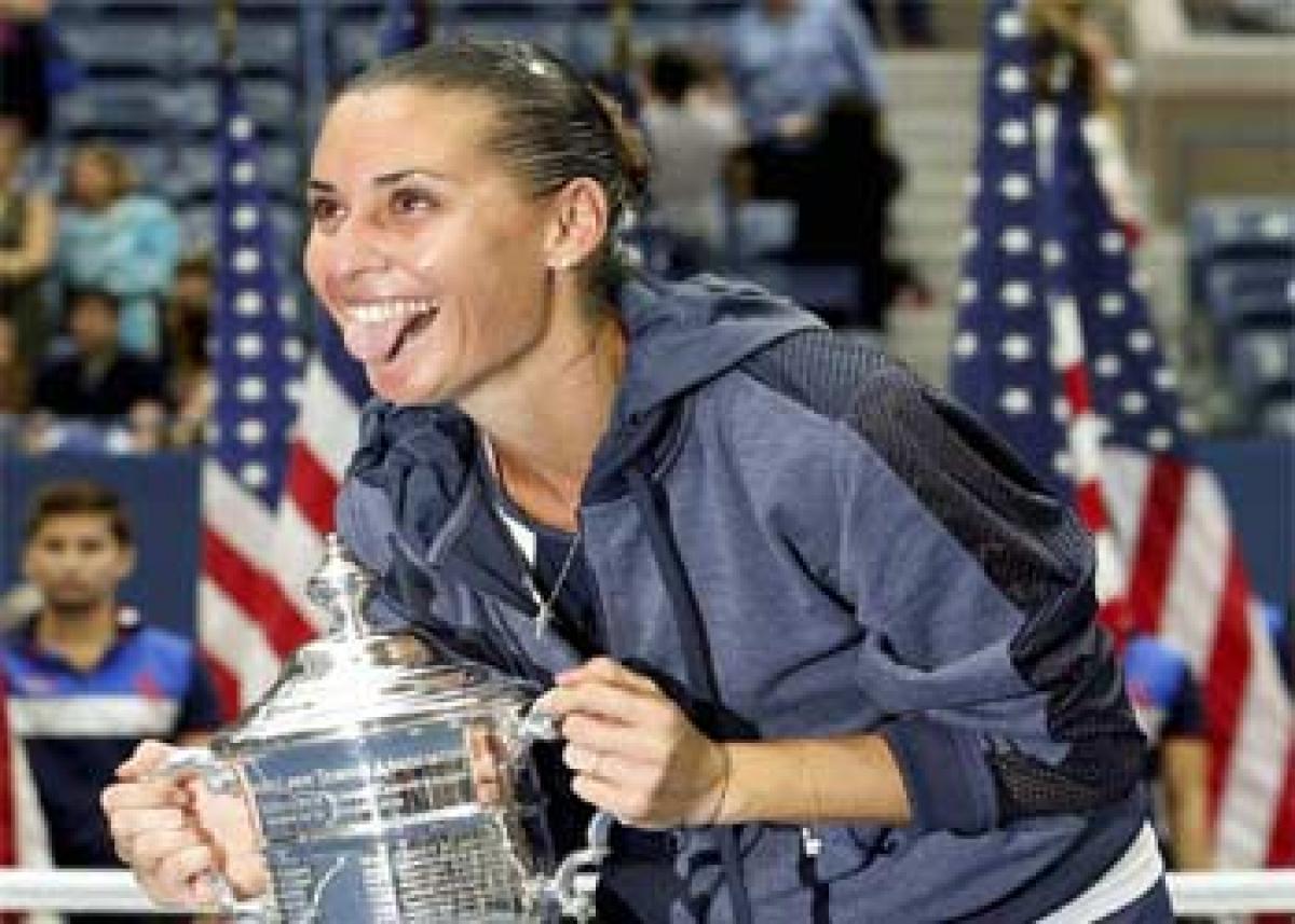 Italian Flavia Pennetta gestures while holding the US Open women singles trophy after beating compatriot Roberta Vinci in New York