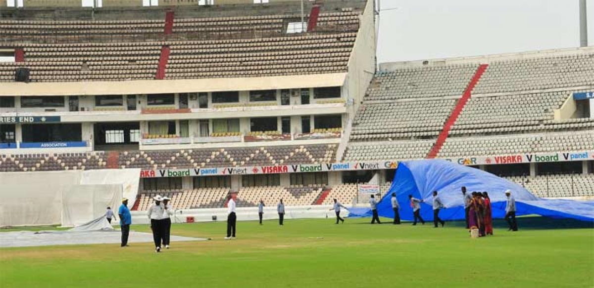 Groundsmen prepare to cover the pitch as rain stops play on the second day of the Moin-ud-Dowla final at Rajiv Gandhi International Cricket Stadium in Hyderabad on Tuesday. Photo: Hrudayanand