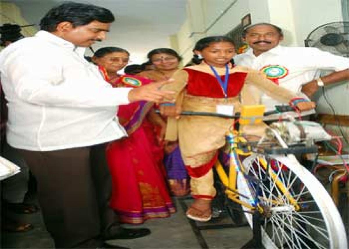 School children being explained a project on 'Conversion of Energy with Cycling' to AP Irrigation minister Devineni Uma, during the State level INSPIRE-2015 exhibition at KBN college in Vijayawada on Monday. Photos: N Kishore
