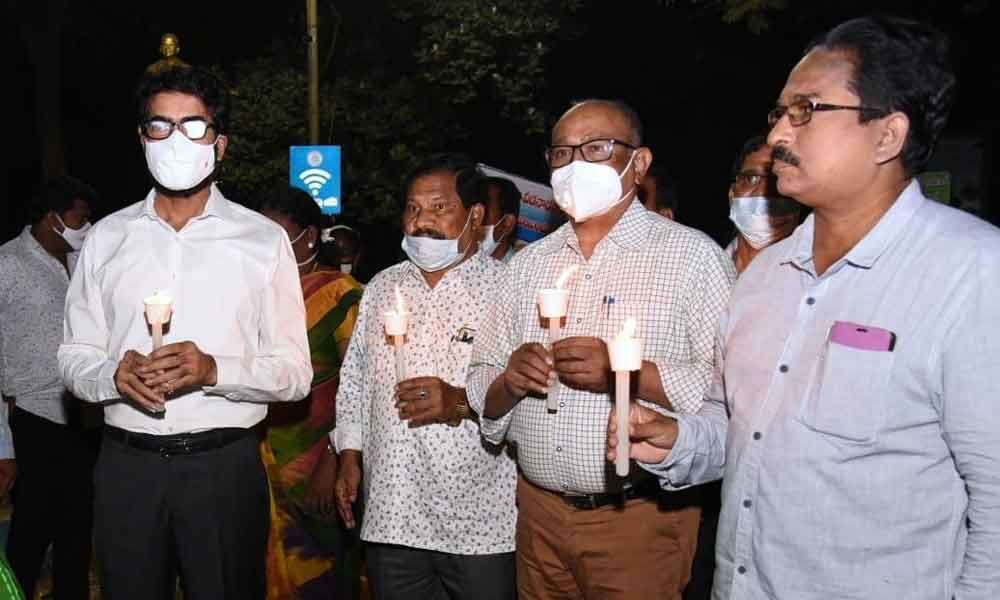 District Collector D Muralidhar Reddy and other officials participating in a candlelight rally in Kakinada