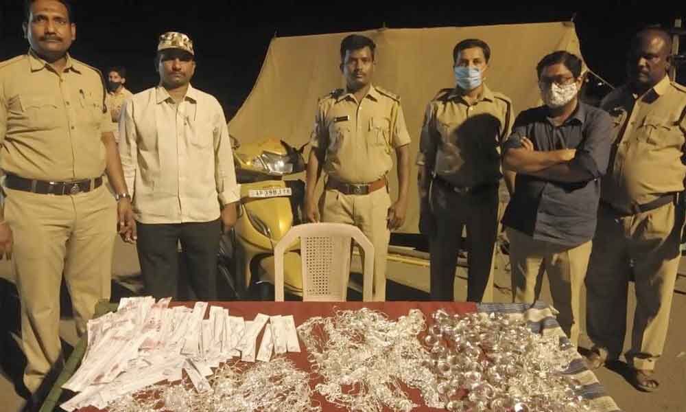 SEB Circle Inspector N Lakshmi Durgaiah with seized silver ornaments at Panchalingala border check post on Monday SEB Circle Inspector N Lakshmi Durgaiah with seized silver ornaments at Panchalingala border check post on Monday