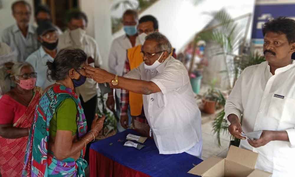 Lions Club former governor Grandhi Venkateswara Rao distributing spectacles in Rajamahendravaram on Friday. Swarnandhrafounder  Dr Gubbala Rambabu is also seen