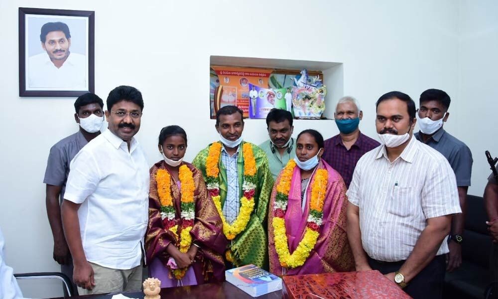 Minister Dr Audimulapu Suresh appreciating M Pallavi and her parents at his camp office in Markapuram on Thursday