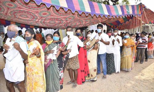 Voters stand in long queue at a polling booth to exercise their franchise in Anantapur on Thursday